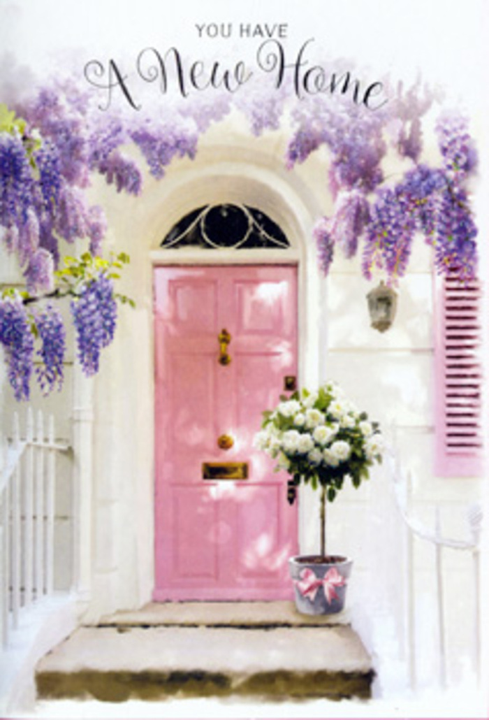 This atmospheric image captures a Broxbourne doorway dressed for a fresh chapter in life, as if waiting to greet new homeowners after a stroll along the High Road. A gently painted pink door, not too bright yet full of charm, anchors the scene with its warm, inviting tone. The door is set into lightly textured, whitewashed walls that hold traces of soft shadow, suggesting an afternoon sun slipping towards the horizon. Above, wisteria cascades in loose, fragrant swathes, the hanging clusters of lavender and soft lilac blooms creating a natural canopy that feels both romantic and slightly wild, like a garden that has grown contentedly over many seasons. Just in front of the threshold, a classic, slightly weathered metal bucket in a cool grey hue sits squarely on the step, brimming with a lush gathering of white and cream roses. Each bloom is full and rounded, some tightly budded, others more open, revealing layered petals that catch the light. Fine sprays of green foliage weave between the roses, bringing a fresh, garden-picked feel that local Broxbourne florists are known for. A pale pink ribbon encircles the bucket, tied into a neat bow whose satin tails lie gracefully against the metal, echoing the colour of the door and tying the whole composition together. The interplay of pastel tones, soft light, and natural texture creates a soothing, hopeful mood, ideal for marking a housewarming, new tenancy, or the quiet joy of turning a key in a new lock. It feels like a moment held just before arrival: flowers waiting, doorway ready, and a sense that this place is about to become a true home.
